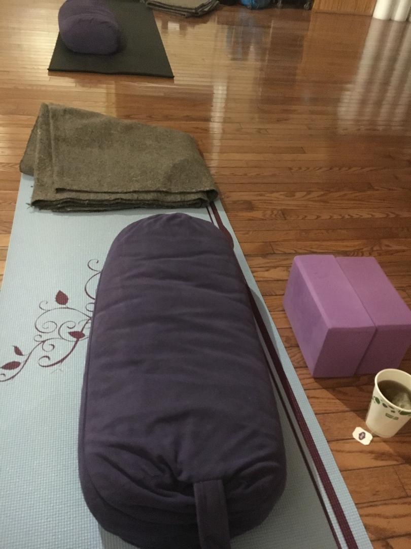 yoga accessories like a bolster, a block, and a blanket are classic. The yogi tea adds to pampered yoga wellness. 