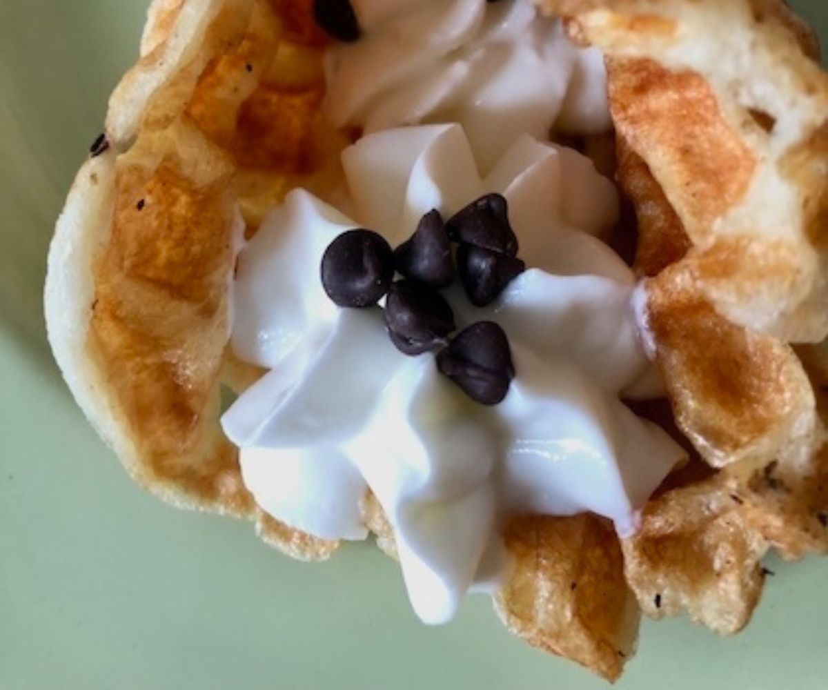 egg waffle with piped in Greek yogurt and chocolate chips.