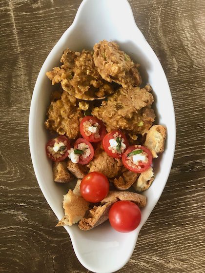 Falafel nuggets with stuffed tomatoes and crunchy bread for a snack.