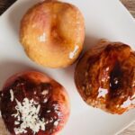 These peaches are glazed with egg white, honey, unsweetened coconut, and melted dark cacao.